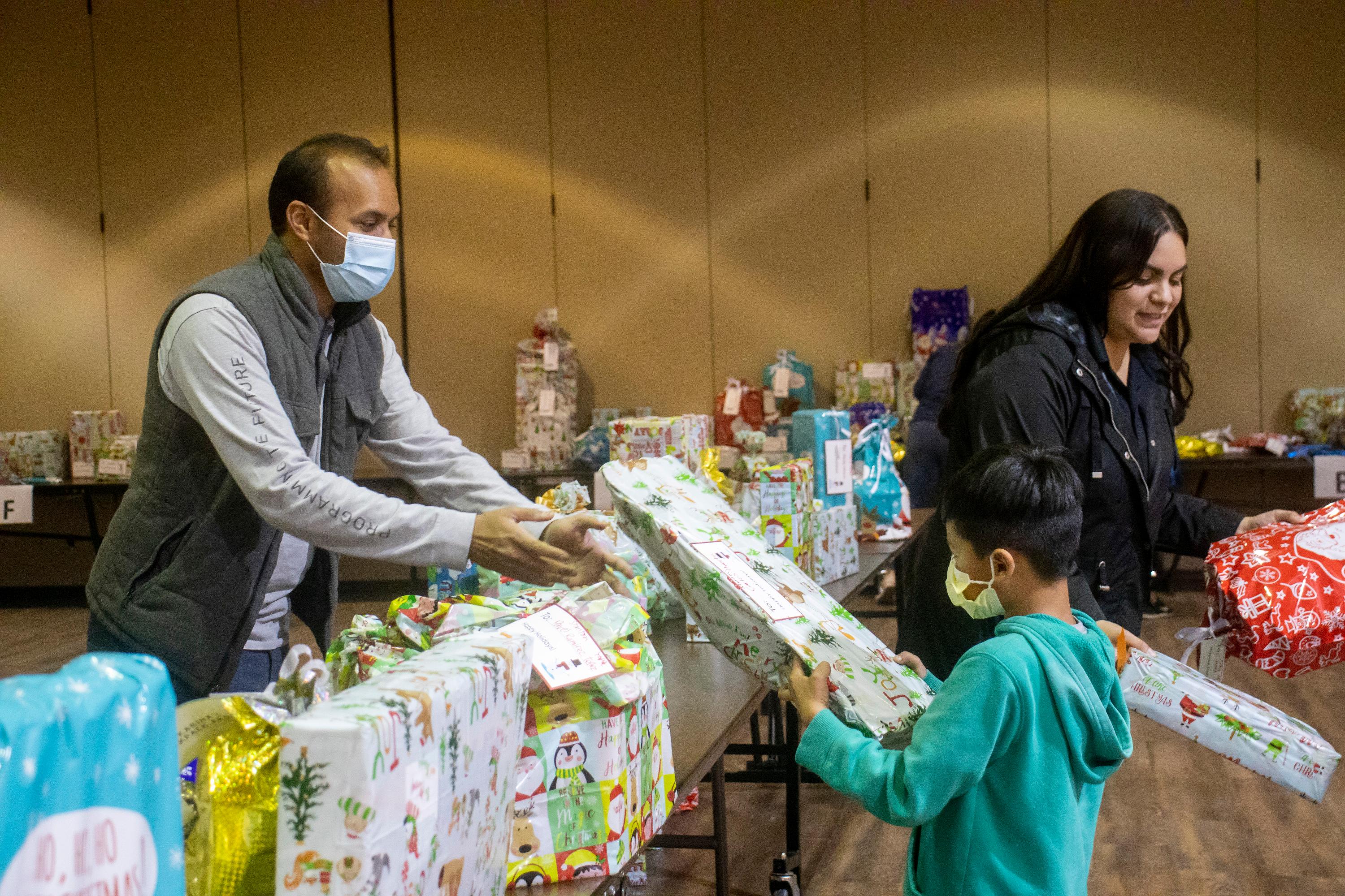 CEO of Dreams for Schools, Nithin Jilla and Stanton Community Services Coordinator, Dianna Valtierra hands out gifts to Stanton children as part of the Katrina's Backpack program.